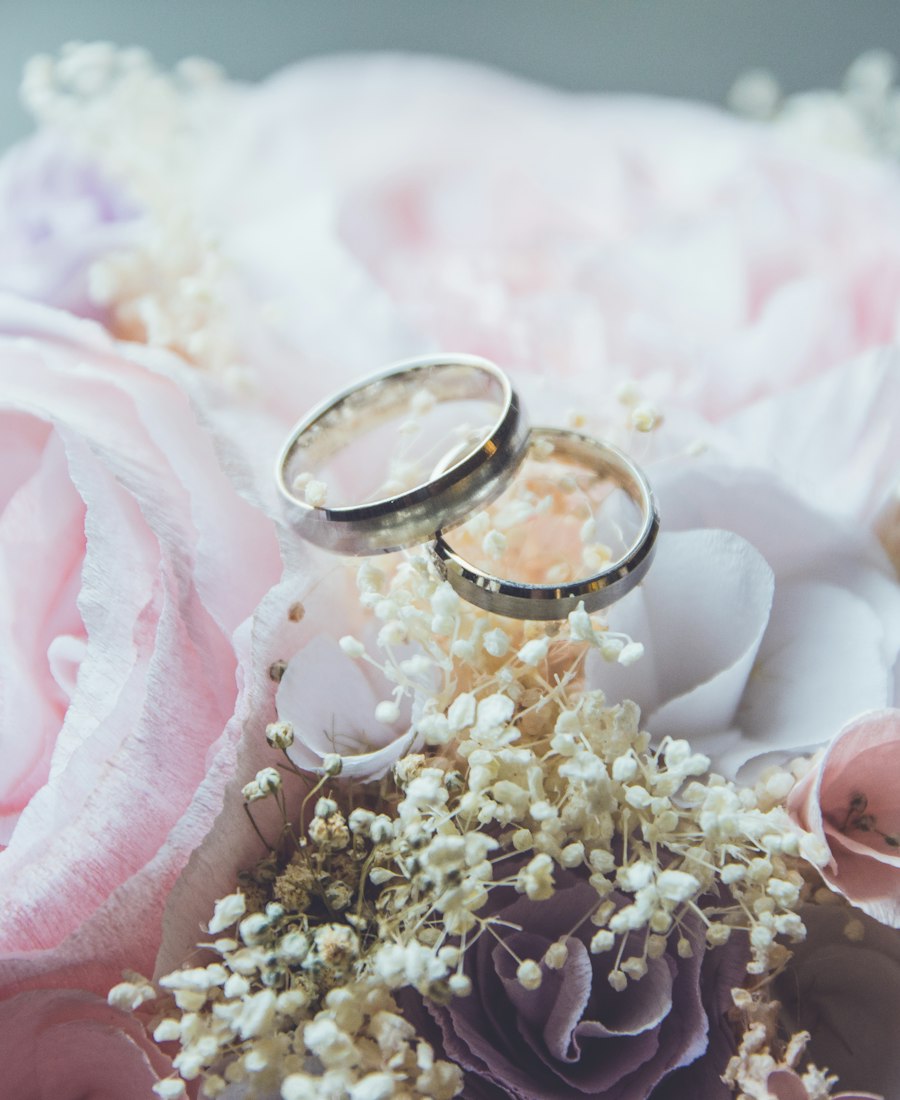 Wedding rings resting on blush roses